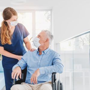 Young,Woman,Nurse,Explaining,Information,To,Man,Patient,In,Wheelchair